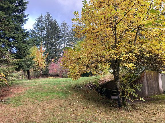Evergreens and blooming trees surround/throughout the property.