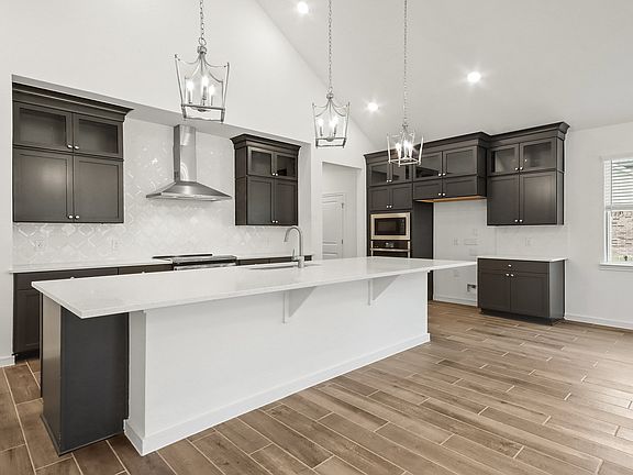 Kitchen with vaulted ceiling, island and pendant lighting