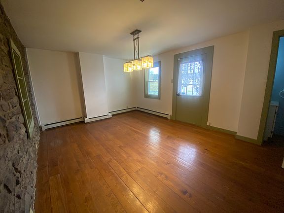 Formal dining room with original wood floors and stone accent wall.