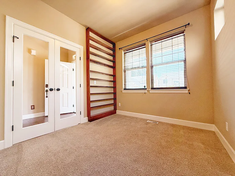 Office with built-in shelves and French doors.