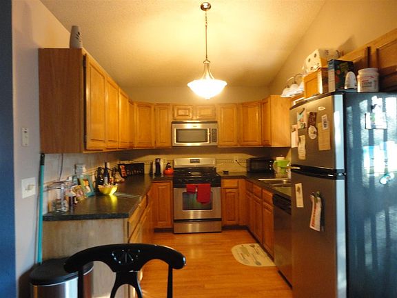 Kitchen has same flooring as living and dining room.  Stainless steel appliances remain, dishwasher, microwave, gas stove/oven, refrigerator and disposal.