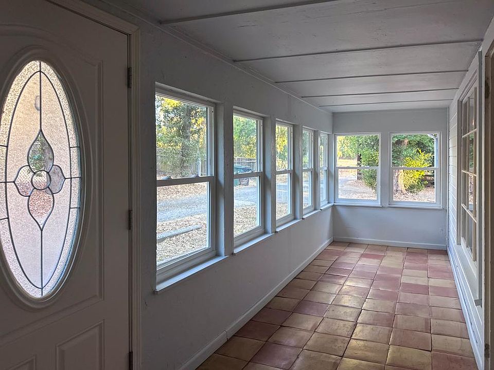 Sunroom with Mexican floor tile. The sunroom looks out to a large, open half acre field.
