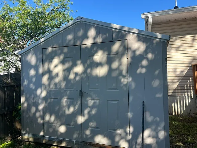 fenced in back yard with a large shed for storage