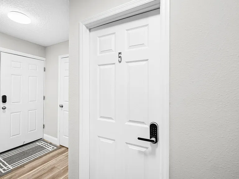 Entry hallway with durable flooring, overhead lighting, and secure keyed entry for easy coming and going.