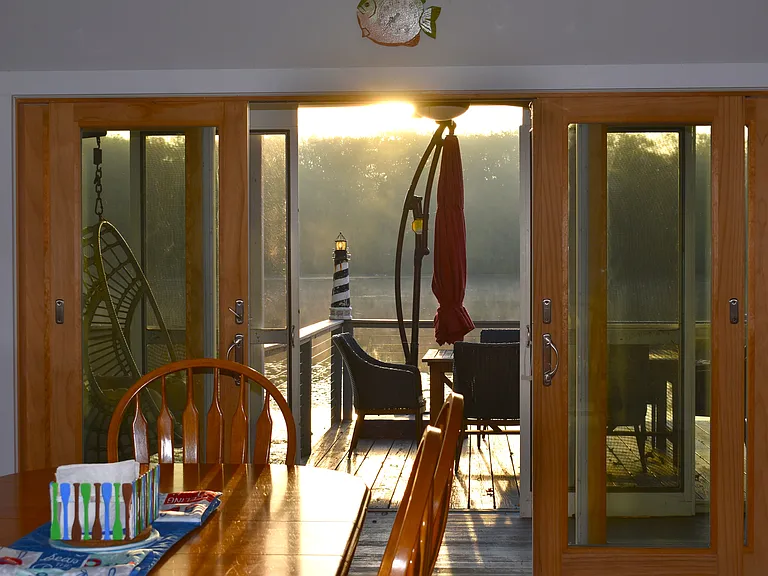 Sunset streaming from the screen porch and splashing onto the dining room area