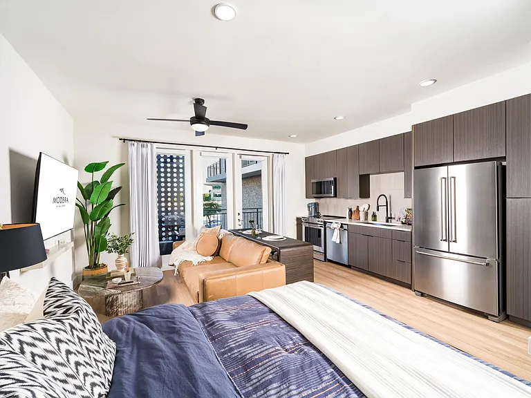 Smartly designed studio layout featuring sleek dark cabinetry, stainless steel appliances, and a private balcony that extends your living space.