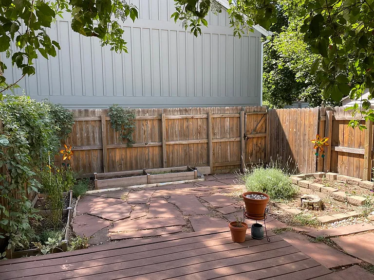 Private fenced backyard with raised garden beds.