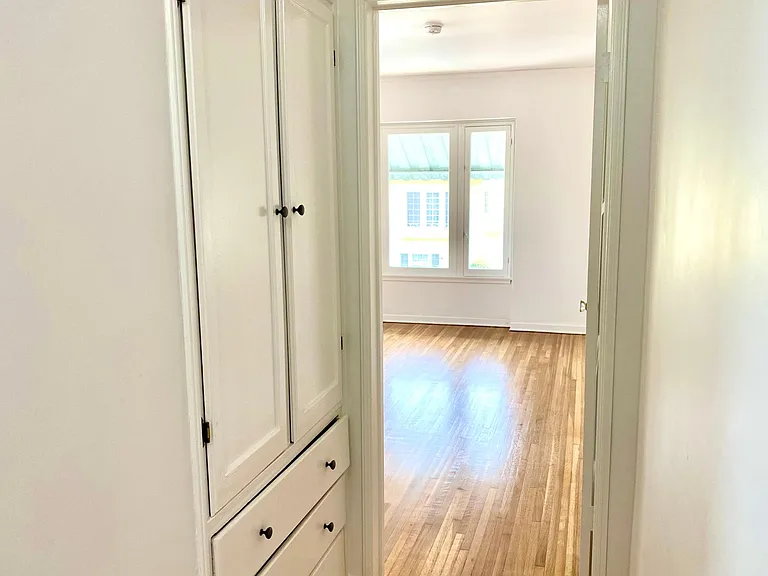 hallway to bedroom with built-in closets