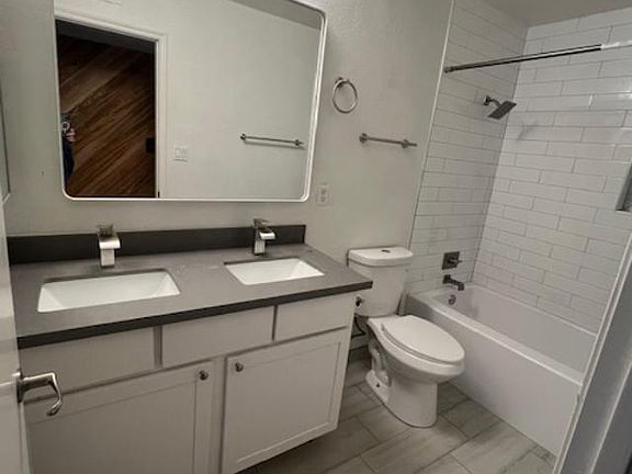 Dual sink, quartz vanity with new tub and subway tiles for hall bathroom