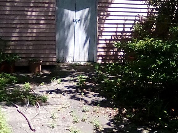 There are flower beds to the right, a wooden fence to the left. The shed is big & safe, but I wouldn't keep any precious objects there. We live next door.