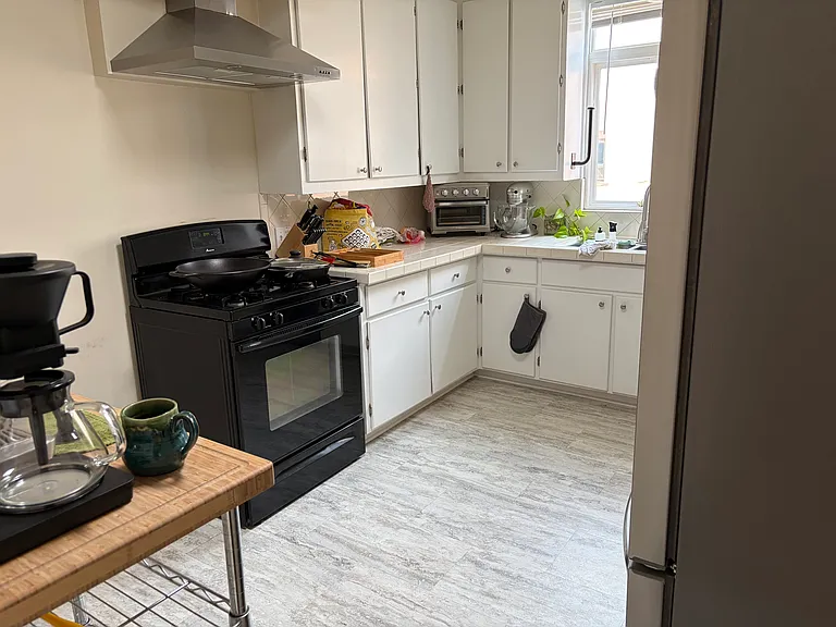 Kitchen with 4 burner gas range, exterior vented rangehood and refrigerator with automatic ice maker/cool water