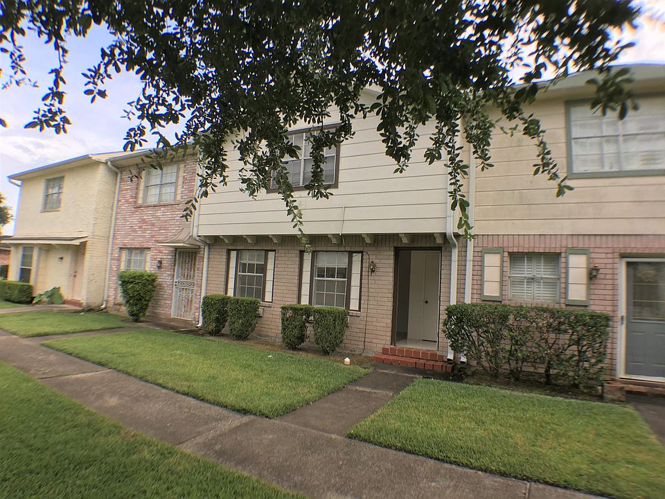 The front of the townhouse with black-trimmed windows. Nice landscape, maintained by HOA