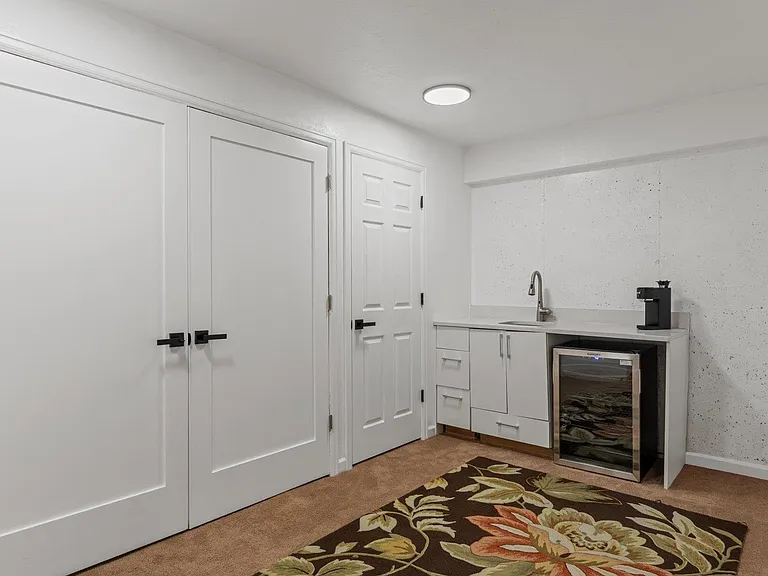Convenient kitchenette nook with sink, base cabinetry, and an undercounter beverage fridge for quick snacks and drinks.