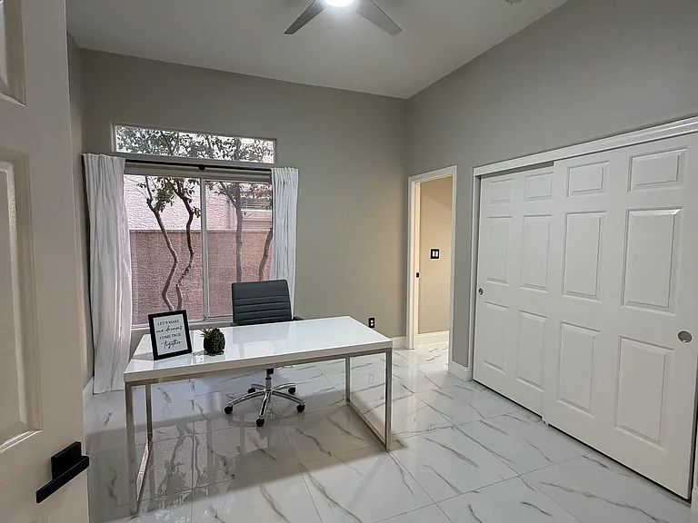 Private office featuring double doors, ceiling fan, and generous closet space