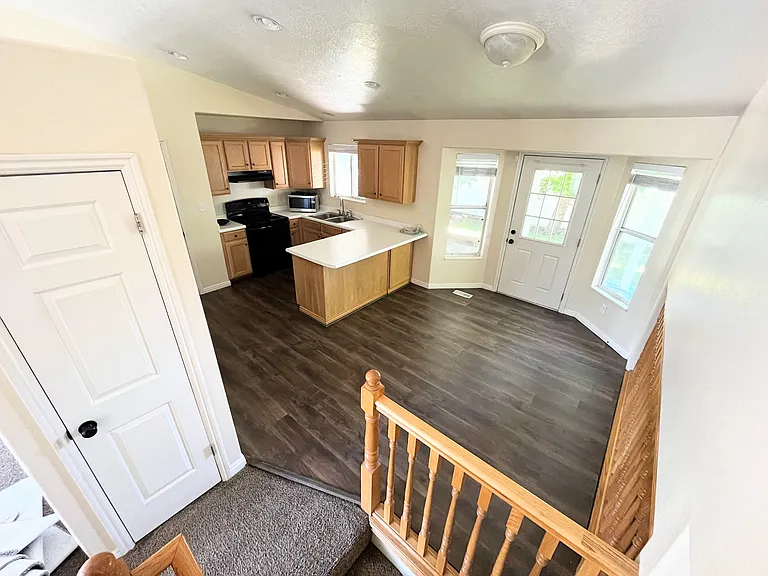 A short wall subtly separates the front living room from the kitchen, creating an open yet distinct layout allowing easy flow and interaction between the two areas.
