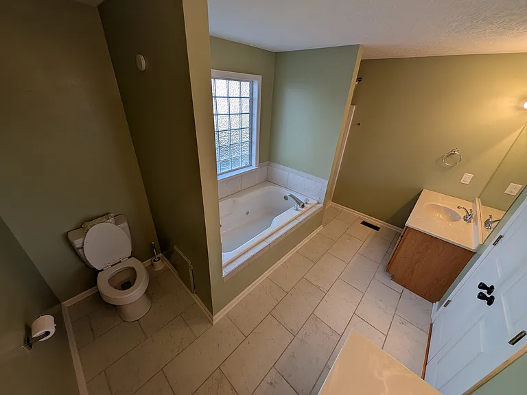 Primary Bathroom with double vanity, separate shower and large bathtub