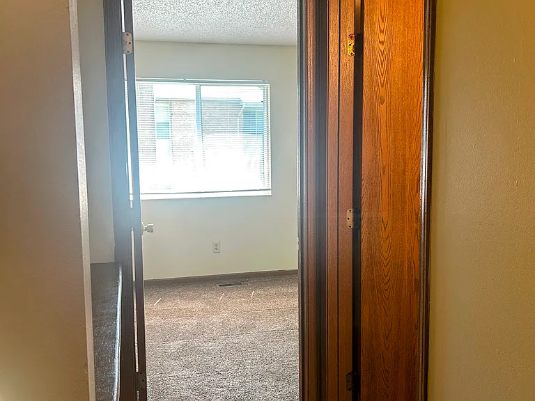 Hallway to full bathroom and second bedroom
