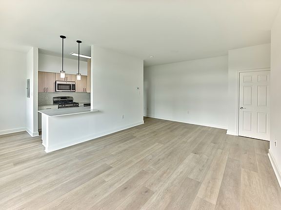 Open-concept floor plan with modern kitchen and wide plank flooring at Crestwood Apartments in Wayne, PA