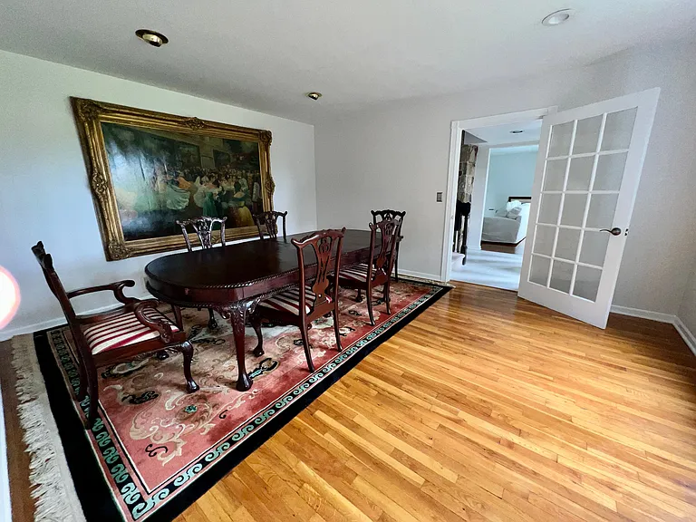 Dining room with furniture. View facing main entrance to the house, stairway to second floor and sunken living room