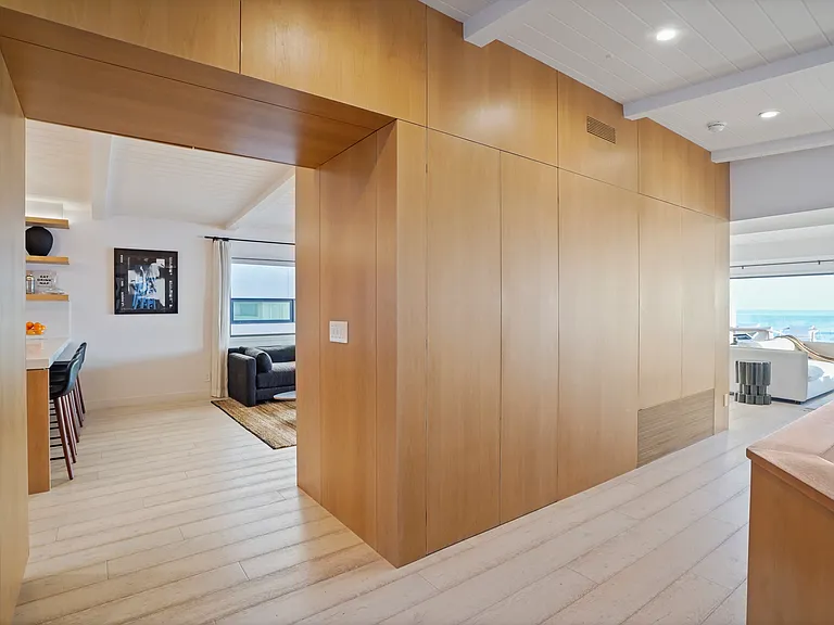 Move through warm wood-paneled interiors that open to endless ocean views