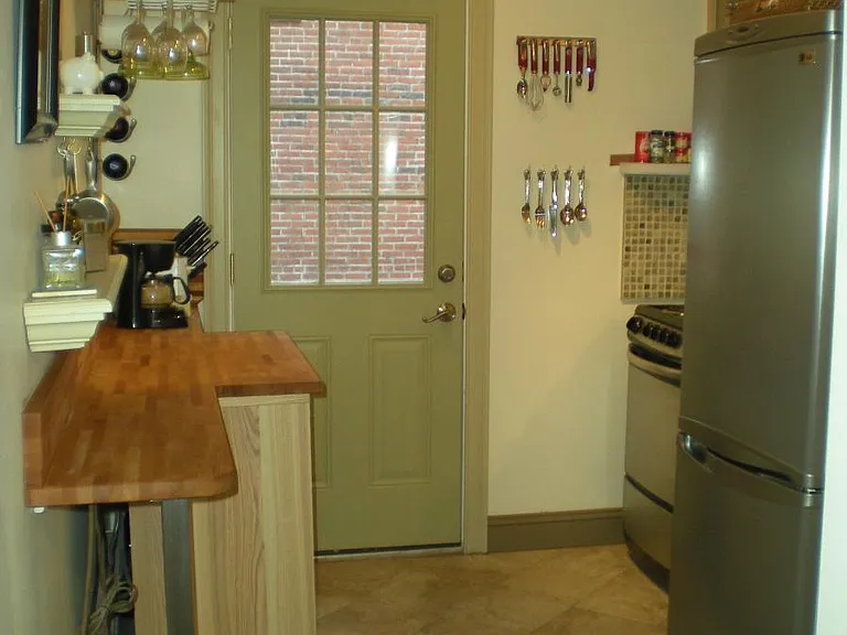 Galley Kitchen with Stainless Steal appliances and butcher block counter top.