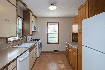 Wonderful galley style kitchen with newer cabinets and windows for natural light