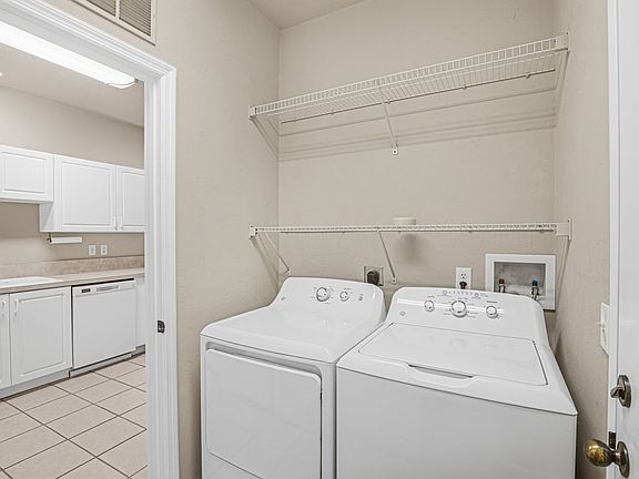 Laundry with washer and dryer and shelving.