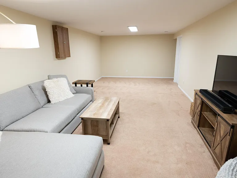 View from the entrance to the additional room towards the stairs and the entry to the laundry and unfinished basement.