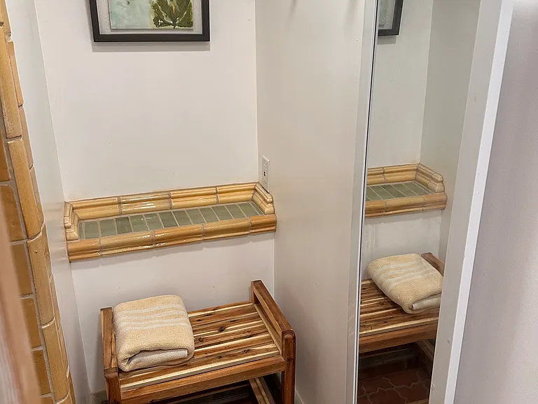 Changing room with bench off shower. pocket doors provide privacy between shower and powder room