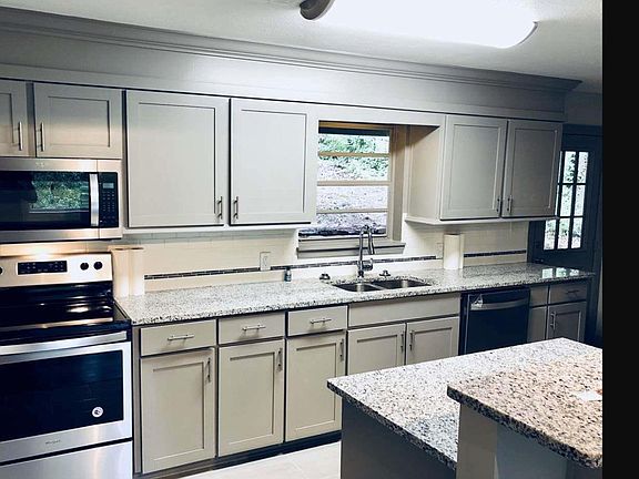 Kitchen with granite counter tops and new appliances.