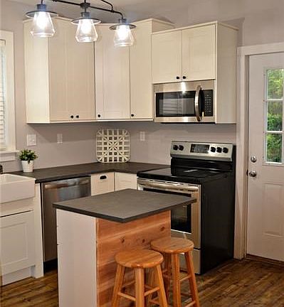 New kitchen, stainless steel stove, microwave, and dishwasher.
