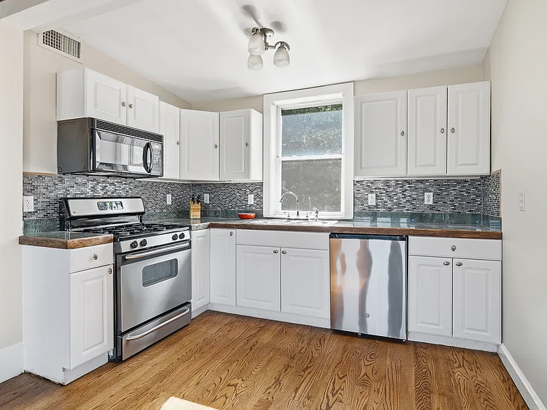 Current Kitchen- bright white kitchen with picture window features stainless steel appliances. (Remodeling will be complete prior to move-in).