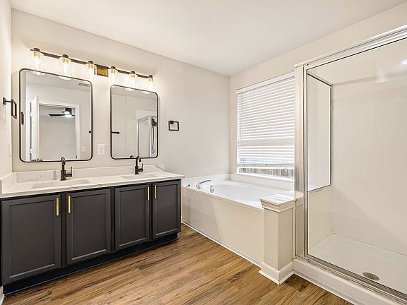 Remodeled Primary bathroom with elegant and modern double sink vanity, quartz counter tops, soaking tub and a shower