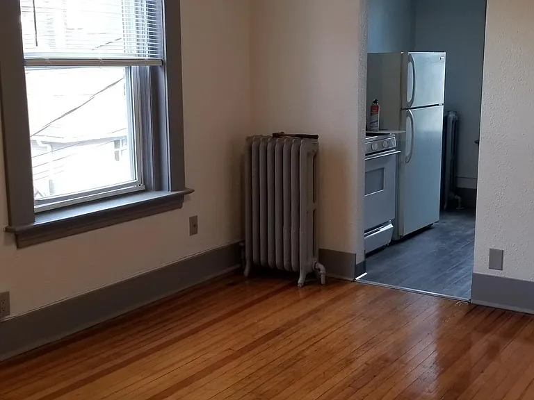 SPACIOUS LIVING ROOM WITH ORIGINAL HARDWOOD FLOORS AND NEW PAINT!
