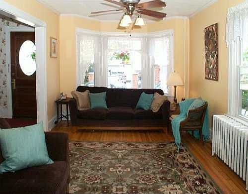 Large living area flooded with sunlight and period details preserved.