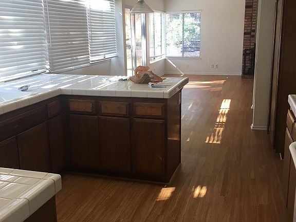 view from kitchen past wet bar on right toward FR, edge of FP on right. 16' wide greenhouse window on left