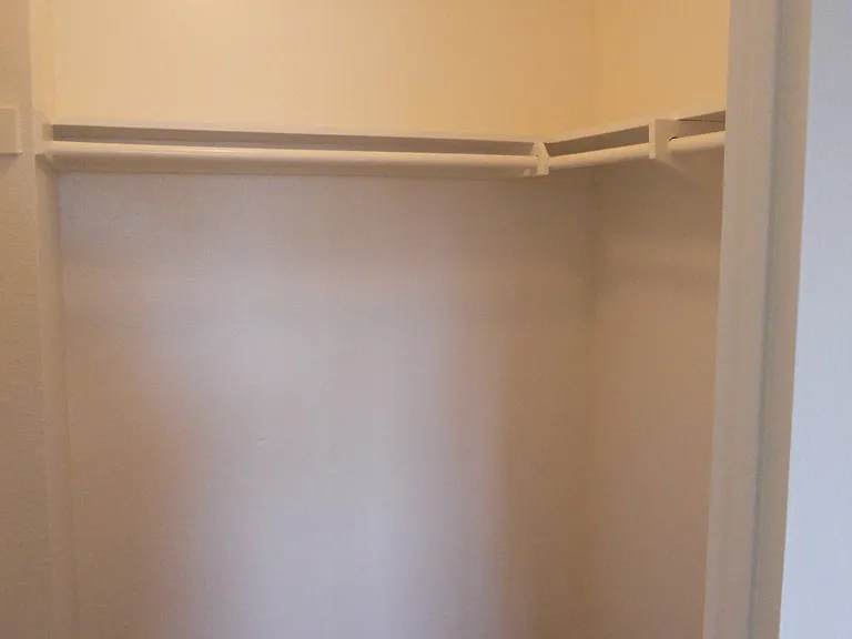 Walk-in closet in carpeted bedroom at Villa Pacific Apartments in Oceanside, California.