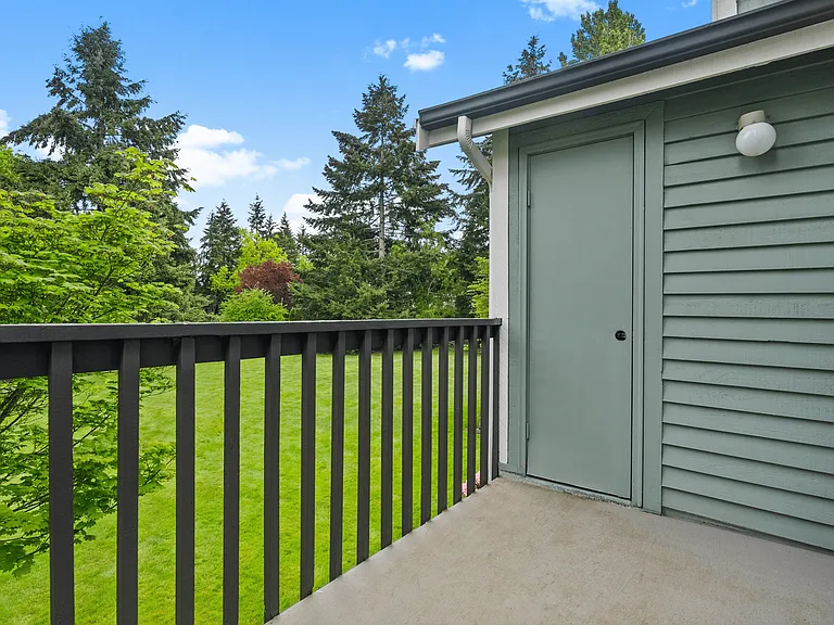 A private balcony offering peaceful views of the surrounding lawn and mature trees, perfect for relaxing outdoors. A private balcony offering peaceful views of the surrounding lawn and mature trees, perfect for relaxing outdoors.