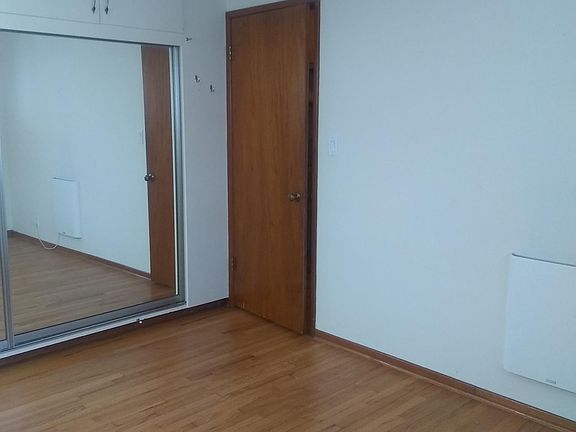 Bedroom with heater, overhead fan, mirror