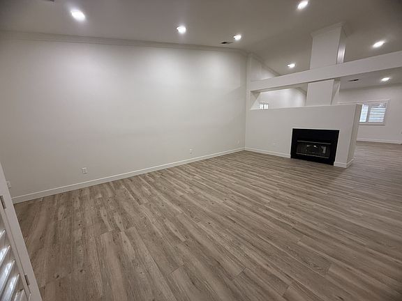 Entrance/Living room, showing gas fireplace, recessed lighting, brand new wood-look tile flooring.