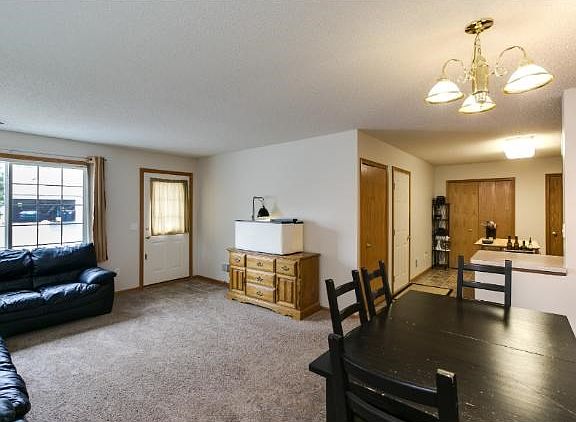 Open view of living room, dining space, and kitchen.