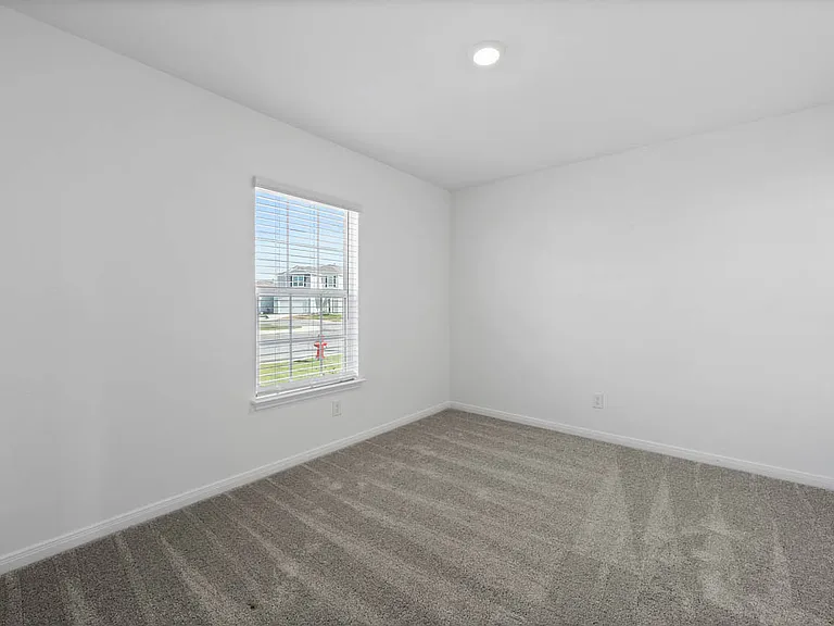 Bedroom with lush carpet and its own closet.