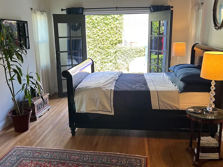 Primary bedroom, French doors open to backyard