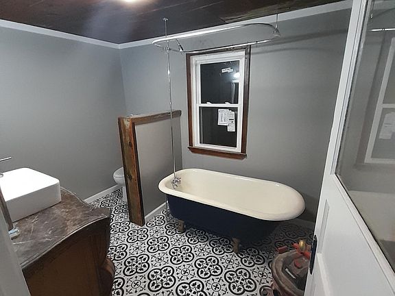 Bathroom with bluetooth speaker in light. Refurbished original claw foot tub