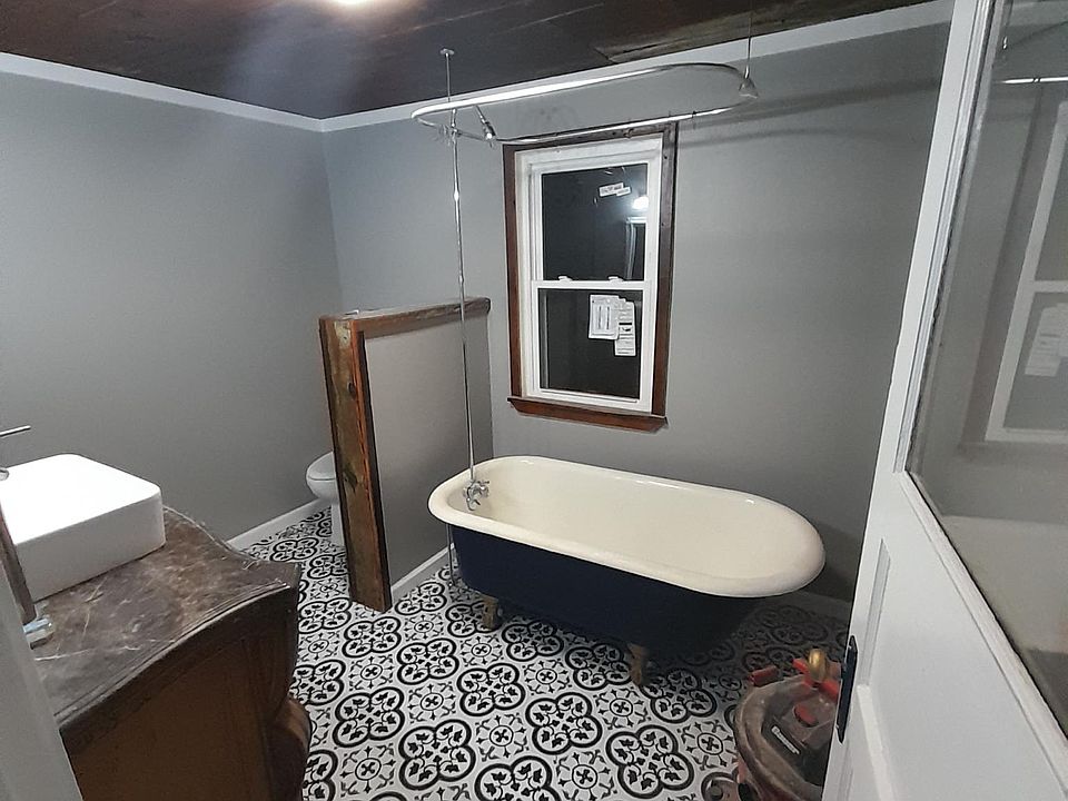 Bathroom with bluetooth speaker in light. Refurbished original claw foot tub