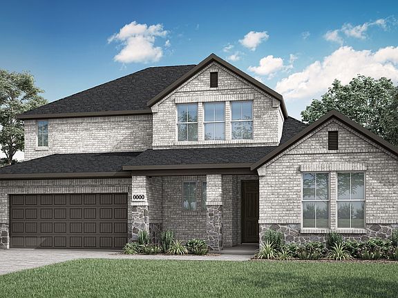A two-story gray stone house with a garage, surrounded by lush greenery and a clear blue sky with fl