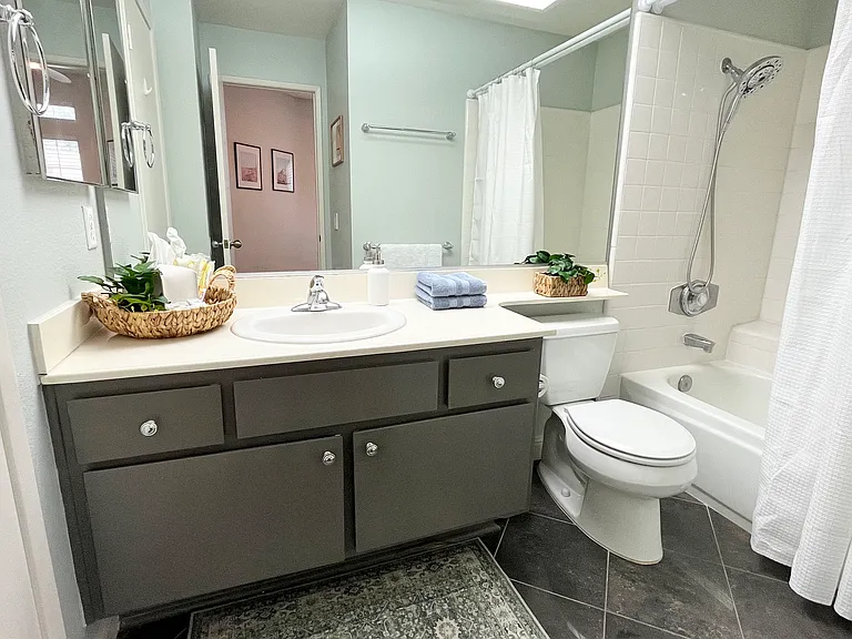The second ensuite full bath offers dual access with doors from the bedroom and living room, featuring a full-size bath tub and a spa-like rainfall showerhead perfect for kids and family use.