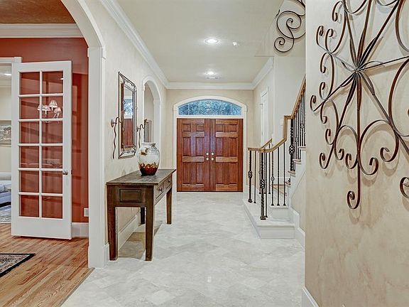 The detail in this home speaks quality and includes features such as the solid wood double front door, iron staircase balusters, polished travertine time, gleaming hardwoods, crown molding, and beautiful millwork.