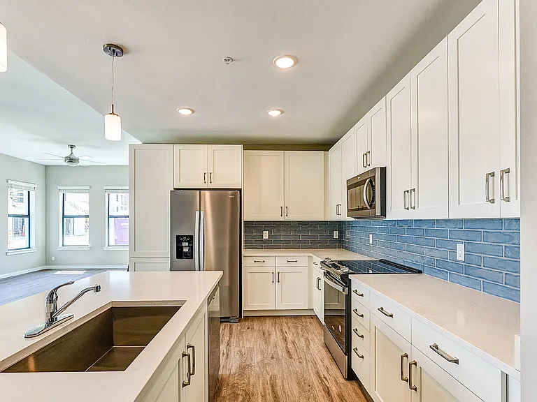 Imperial Crossing Luxury Apartment Homes unit showing a modern kitchen with stainless steel appliances and white cabinets.