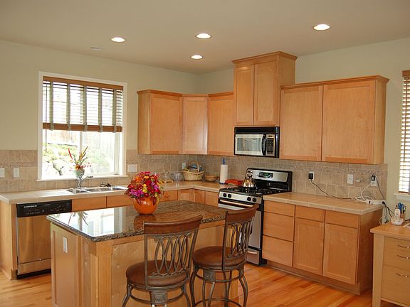   Bright Kitchen with granite &tile counters. Full height tile backsplash. Har